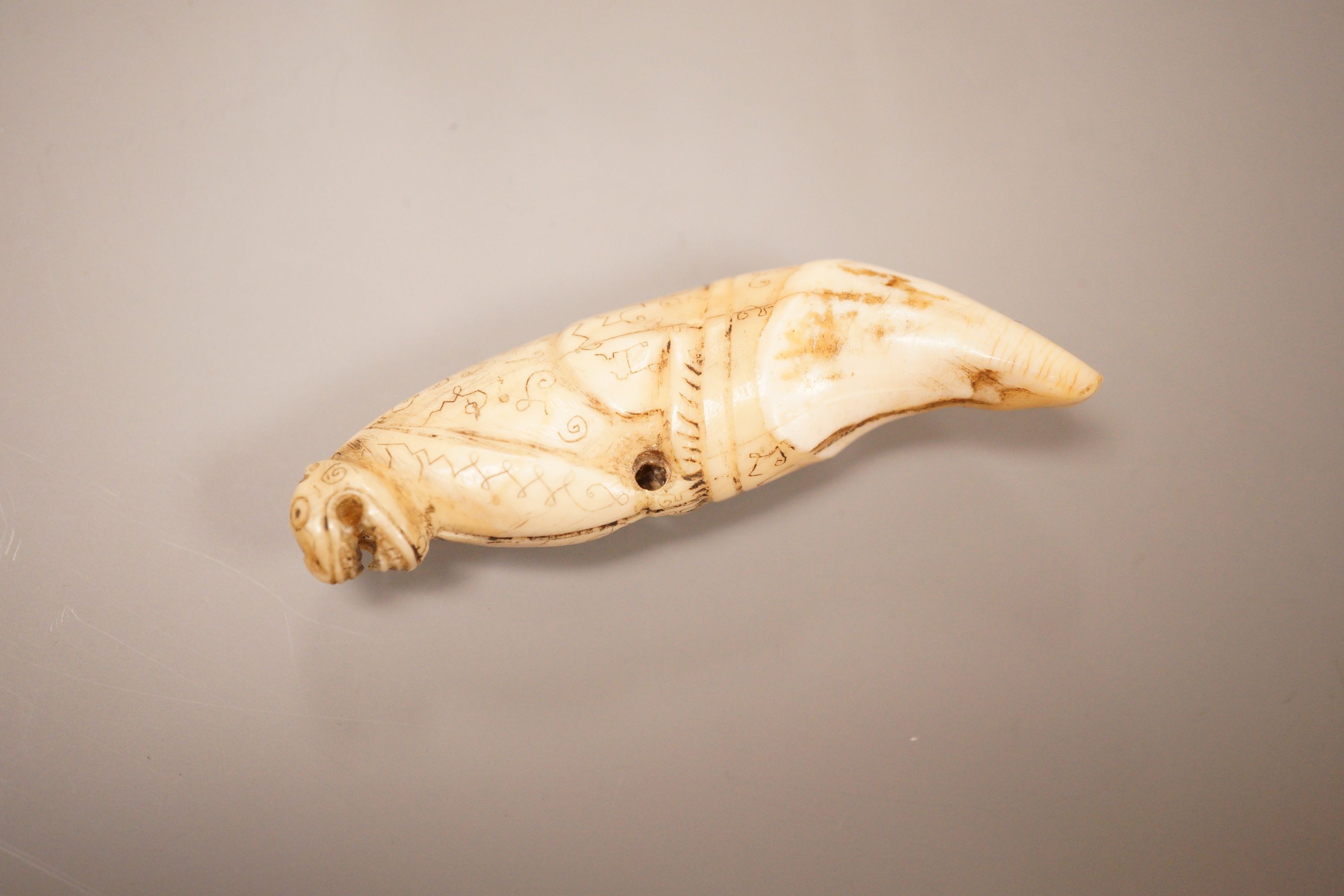 An Inuit whale tooth carving, 19th century, 8cm long, and a marine ivory religious group, possibly Goa